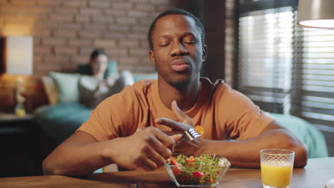Black-Man-Eating-Salad-and-Drinking-Juice-while-Web-Calling